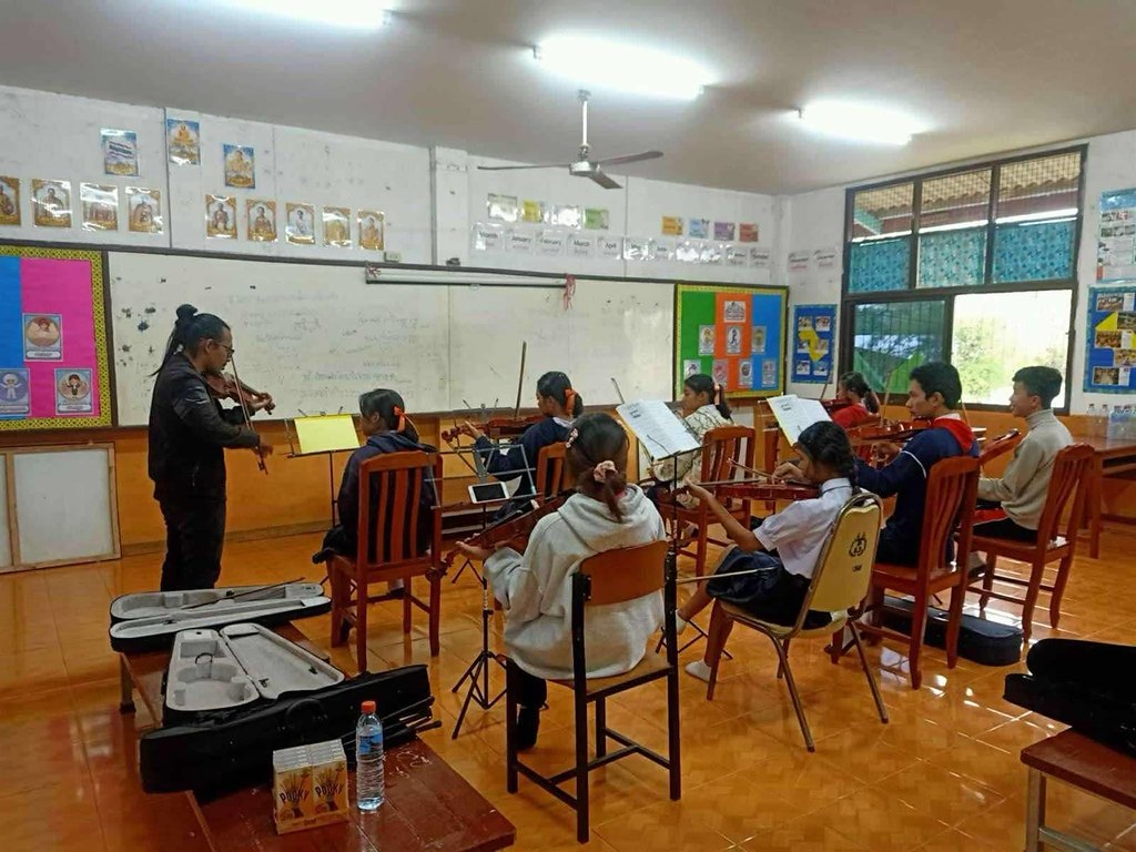 A Burmese musician teaching violin at Mae Ku High School. (Photo from Joy House)