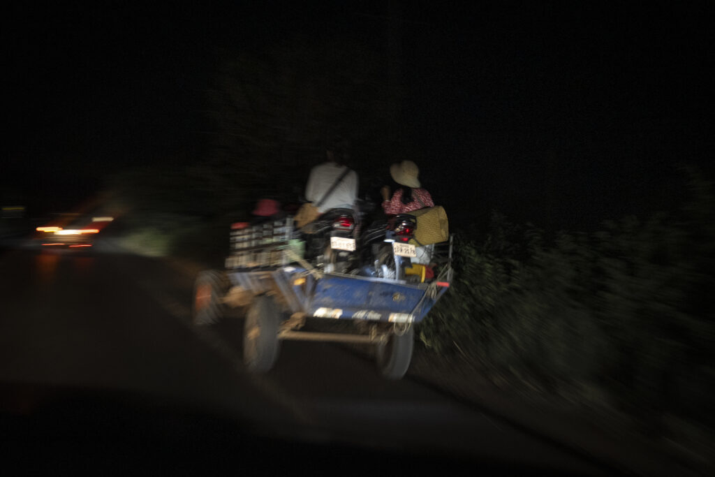 A family carries their motorbikes on a koh yun motorized scooter to move camps during the night in Cambodia’s Siem Reap province on December 15, 2025. (Roun Ry/Mekong Independent)