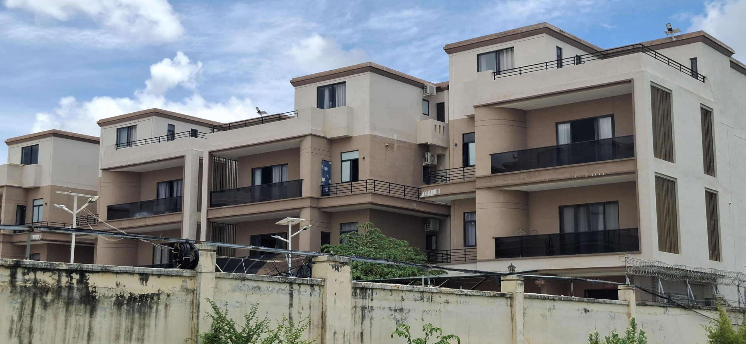 A row of villas in the back of the reported scam center Mango Park, with windows and doors left open, in Cambodia's Kampong Speu province on August 13, 2025. (Danielle Keeton-Olsen/Mekong Independent/Creative Commons)