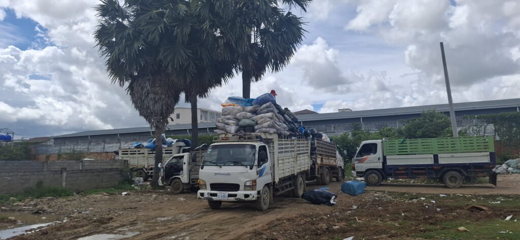 Workers pile garbage bags into trucks outside a compound previously raided for online scams, in Cambodia's Kampong Speu province on August 13, 2025. (Danielle Keeton-Olsen/Mekong Independent)