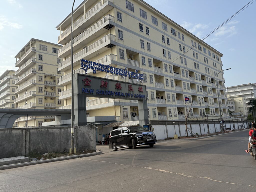 A black van drives out of the gates of the Jincai 5 or New Golden Wealth 5 casino in Cambodia's Sihanoukville city on January 15, 2026. (Mech Dara/Mekong Independent)
