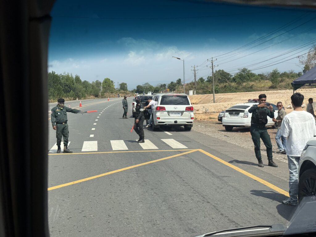 Law enforcement officers stop vans and take pictures of passengers along National Road 48 in Cambodia's Koh Kong province on January 25, 2026. (Mech Dara/Mekong Independent)