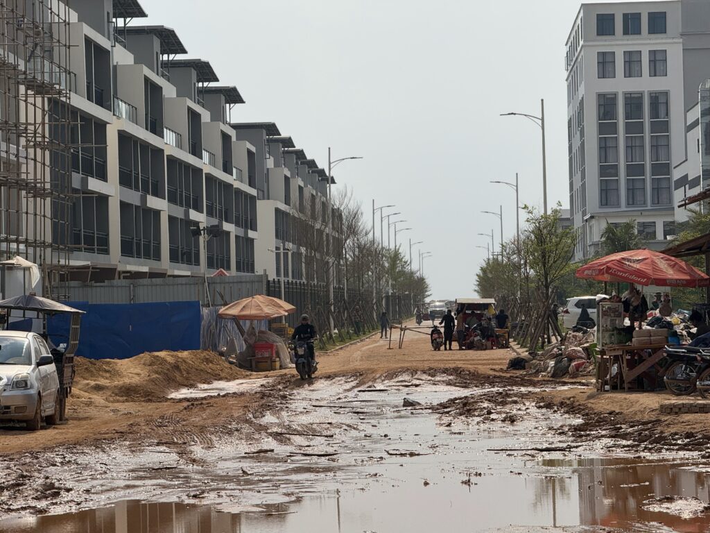 A muddy road between rows of buildings within Dara Sakor Resort complex in Cambodia's Koh Kong province on January 26, 2026. (Mech Dara/Mekong Independent)