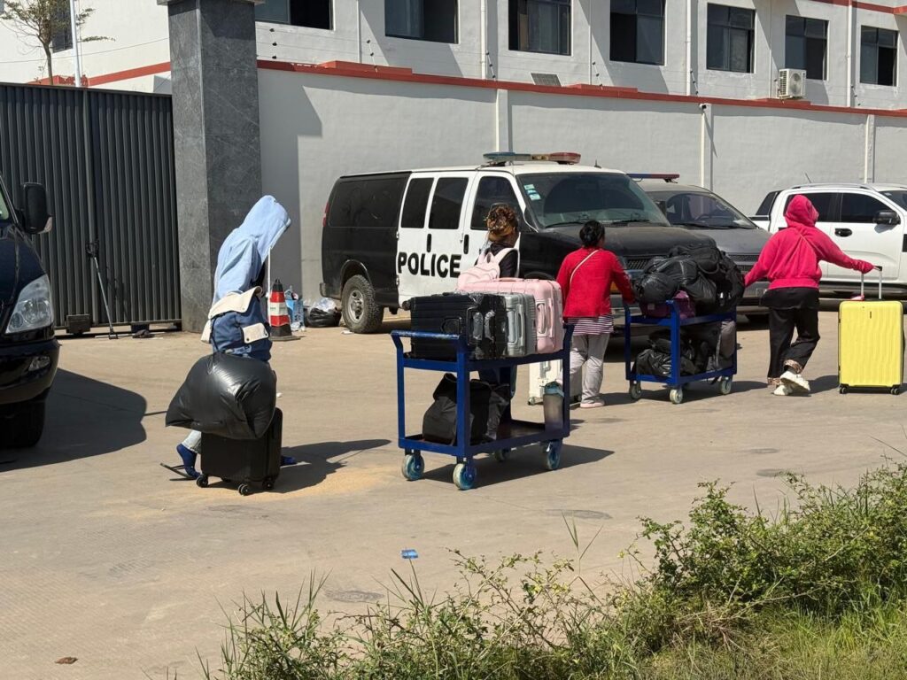 Foreigners bring loads of luggage, some packed onto rolling carts, during a police raid at the A7 Park in Cambodia's Bavet city on February 1, 2026. (Mech Dara/Mekong Independent)