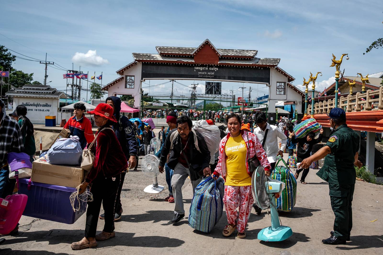Cambodian workers carry their possessions in boxes and travel bags through the Ban Laem Border Gate in Cambodia's Battambang province on Aug. 3, 2025. (Roun Ry/Mekong Independent/Creative Commons)